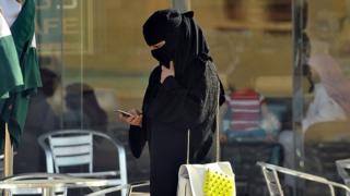 Woman looks at phone in Saudi Arabia