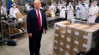 Employees take photos as President Trump speaks during a tour of a US factory.