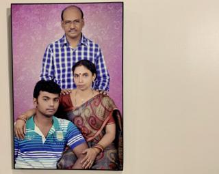 Familienporträt von Choudhury, das an der Wand ihres Hauses hängt