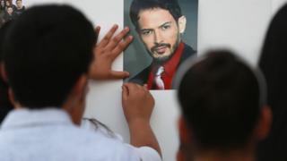 Children pin a photo of Alejandro Fuentes to a wall outside the Tras Bambalinas music school in Chicago, 18 June