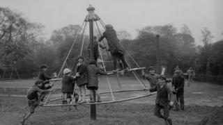 Children playing on a witches hat in 1930