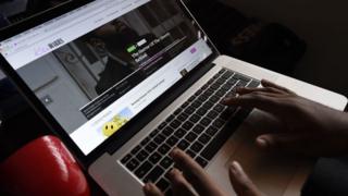 Person dey type ontop laptop