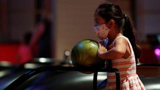 Girl with a mask and a bowling ball