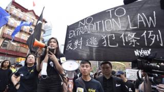 在纽约,她身穿一身黑衣,T恤上写着:"我係香港人(我是香港人)"。