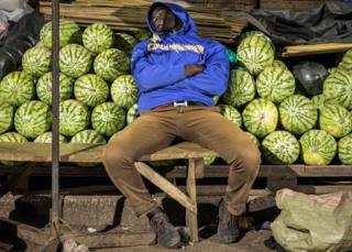 Ein Händler schläft an seinem Melonenstand in Kampala, Uganda - Mittwoch, 8. April 2020