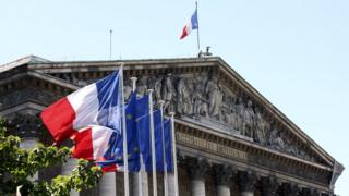 French flags fly outside the National Assembly in Paris