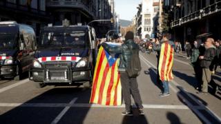A Demonstrator shows a Catalan flag to police during a protest against Spain's cabinet meeting, in Barcelona, December 21, 2018