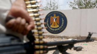 A Yemeni government soldier carries his gun near the South Transat Council in Ataq