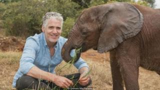 Gordon Buchanan dengan bayi gajah, David Sheldrick Wildlife Trust, Kenya.