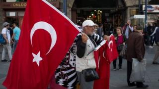 Мужчина продает турецкие флаги в Стамбуле. Фото: 3 мая 2015 г.