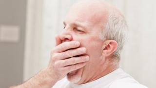 older man yawning