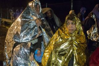 Migrants wait to cross into Slovenia, at a border crossing with Croatia, in Sredisce ob Dravi, early Monday, 19 Oct 2015