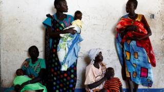 Женщины держат своих детей в ожидании медосмотра в мобильной клинике при поддержке Unicef ??в деревне Нимини, штат Юнити, Южный Судан