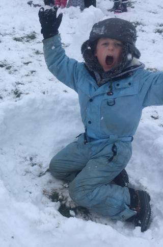Image of a child looking happy in the snow