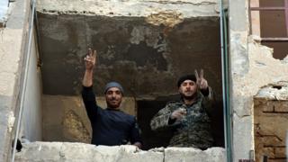 Syrian soldiers making a V for victory sign from a window of damaged building in Aleppo's eastern Masaken Hanano area in Aleppo province, Syria, 27 November