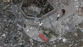 Men walk through a debris-covered street