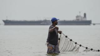 A fisherman hauls in his net in Lake Maracaibo in the Venezuelan city of Maracaibo, on 15 March 2019.