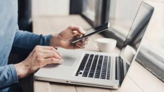 Usuário com laptop e smartphone