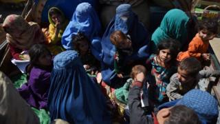 Афганские женщины и дети сидят в грузовике