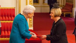 The Queen handing over a medal to Doreen Kenny