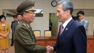 Mshauri wa raia kuhusu maswala ya usalama wa Korea Kusini Kim Kwan-jin kulia akiamkuana na afisa wa ngazi za juu wa jeshi la Korea Kaskazini