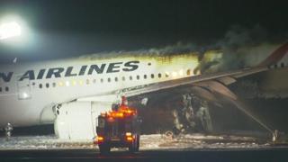 Japan Airlines plane in flames on a runway at Tokyo's Haneda airport