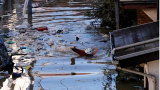 冠水した住宅地の道を調べる消防職員(13日、川崎市)