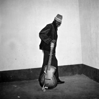 A man posing with a guitar