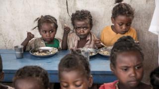 Schoolchildren from Ankileisoke Primary School eat lunch, offered by the World Food Programme's Under-nutrition Prevention Programme, in the Amboasary-South district of southern Madagascar, on December 14, 2018.