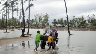 Bangladeshi people walk with their belongings towards a safer area near the coast at the Cox's Bazar district in Chittagong, 30 May 2017