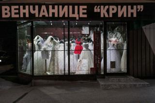 The window of a wedding dress shop lit at night