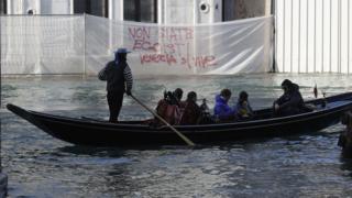 A boat sails past a writing reading "Don"t be selfish, Venice is to be lived" during a protest against the increasing number of tourists in Venice, Italy, Saturday, Nov.12. 2016