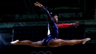 Simone Biles en el aire en una rutina de gimnasia olímpica en Río