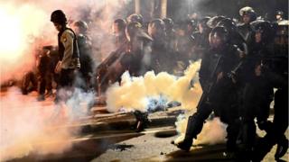 Indonesian police shoot tear gas to disperse protesters during a demonstration outside the Elections Oversight Body (Bawaslu)