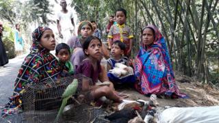 লালমনিরহাটের আদিতমারি উপজেলার একটি গ্রামে রাস্তার উপর অপেক্ষা করছেন মেহেরবান বিবি ও আর্জিনা বেগমের পরিবার।
