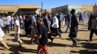 Sudanese demonstrators march along the street during anti-government protests after Friday prayers