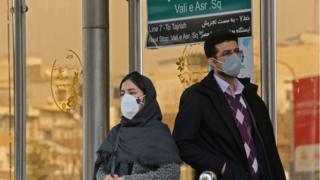 Người dân ở thủ đô Tehran, Iran đeo khẩu trang tại một bến xe buýt. Iran đang có tranh cãi về số người tử vong do dịch Covid-19
