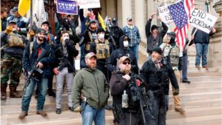 People take part in a protest for "Michiganders Against Excessive Quarantine" at the Michigan State Capitol in Lansing, Michigan on April 15, 2020