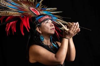 Mexican Elena Garcia, dancer of a pre-Columbian ballgame called "Ulama" -in Nahuatl indigenous language- and whose costume represents her name "Aquetzalli Tlayotzin" (precious water heart of the earth), poses for a photograph during a photo session at the FARO Poniente cultural centre in Mexico City on August 21, 2019.