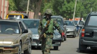 An officer of the Joint Military Task Force (JTF) walks on the road in the northeastern Nigerian town of Maiduguri, Borno State , on April 30, 2013.