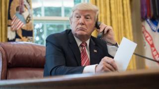 US President Donald Trump makes a phone call in the Oval Office at the White House in Washington, DC, on June 27, 2017