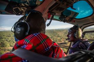 Ambrose Ngetich und Captain Iltasayon ​​Neepe schauen aus dem Cockpit eines Hubschraubers