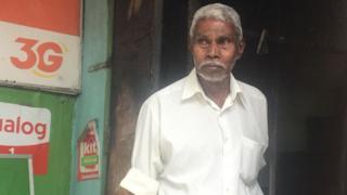 దాడుల్లో ధ్వంసమైన తన దుకాణం ముందు థయాప్