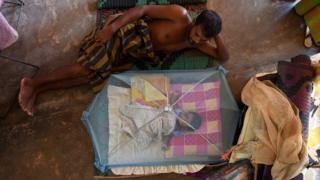 A Sri Lankan child and man rest at a relief camp after being evacuated following flooding in the suburb of Kaduwela in the capital Colombo on May 28, 2017. Emergency teams rushed to distribute aid on May 28 to half a million Sri Lankans displaced after the island's worst flooding in more than a decade claimed 126 lives and left scores more missing. / AFP PHOTO / Ishara S. KODIKARA (Photo credit should read ISHARA S. KODIKARA/AFP/Getty Images