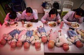 Chinese women training to be qualified nannies, known in China as ayis, eat their lunch