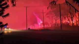 A night sky lit a dark red from a bushfire at the coastal village of Harrington in New South Wales on 29 October