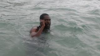 Mvuvi akionyesha wanavyowasiliana kwa simu ndani ya bahari hindi