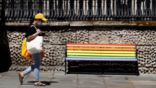 Woman walks past a bench