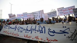 Суданские протестующие выкрикивают лозунги и развевают плакаты во время демонстрации в Хартуме 14 мая 2019 года