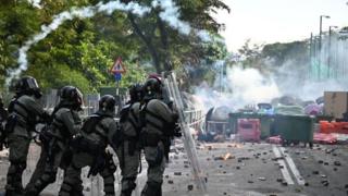 Police (L) fire tear gas towards protesters (back) at the Chinese University of Hong Kong (CUHK), in Hong Kong on November 12, 2019